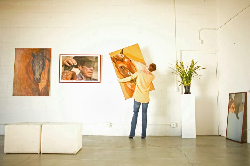 Owner hanging art in gallery