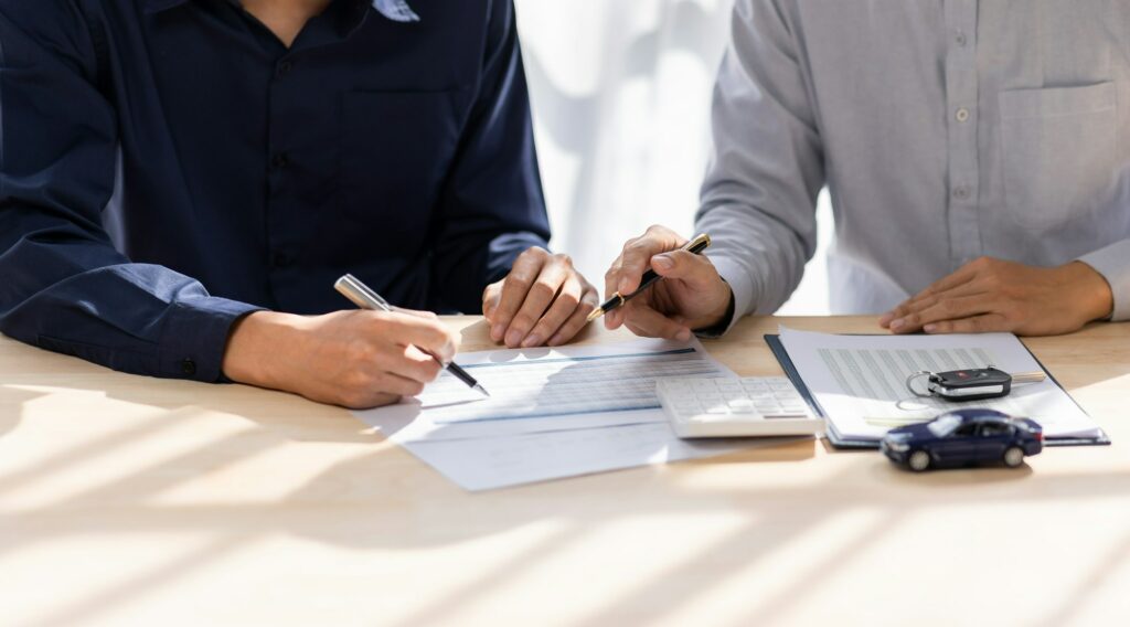 Car Insurance document or lease concept the car broker assisting his customer and explaining the